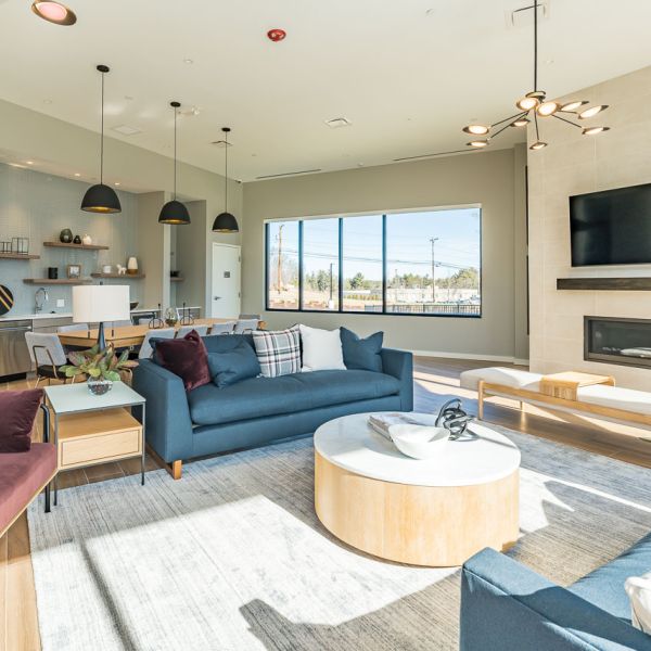Clubhouse lounge at the curtis with fireplace, tv and kitchen